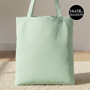 Light green tote bag on a neutral background with size label.