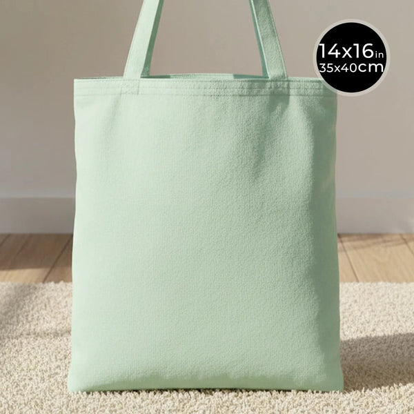 Light green tote bag on a neutral background with size label.
