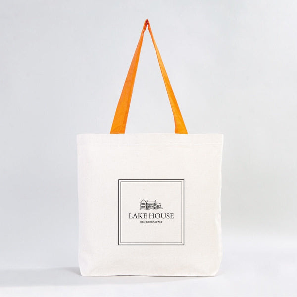 White tote bag with orange handles and 'Lake House' logo on a light gray background