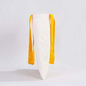 White pillow with yellow straps on a light gray background