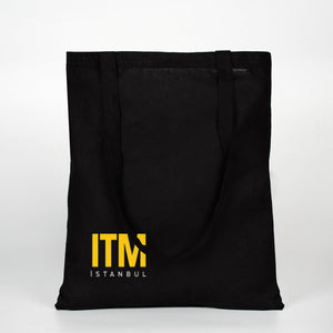 Black tote bag with yellow 'ITM Istanbul' logo on a white background