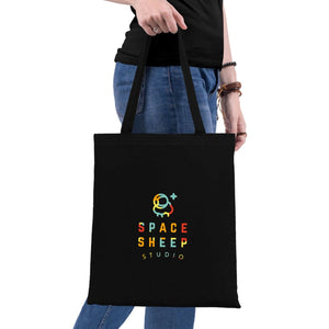 Black tote bag with 'Space Sheep Studio' logo held by a person on a white background