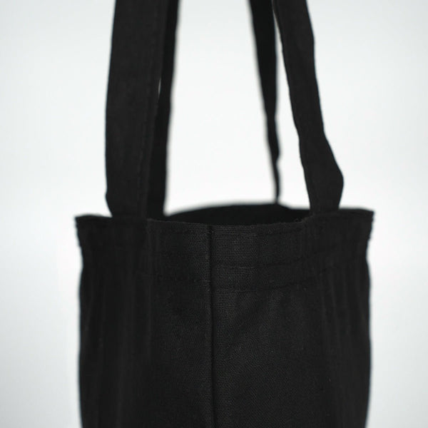 Black tote bag with straps on a white background