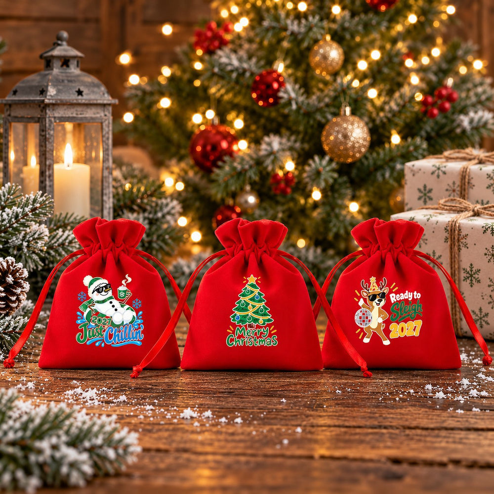 Pochette cadeau Noël en velours rouge, motif Noël à Paris tour Eiffel, sur une table rustique enneigée devant le sapin