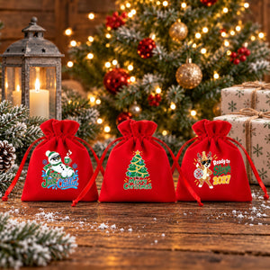 Trois pochettes en velours rouge sur une table rustique enneigée : lutin farceur, Noël à Paris et Secret Santa